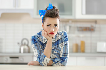 Poster - Portrait of funny young housewife in kitchen