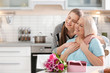 © New Africa - Daughter congratulating happy mature woman on Mother's Day at home