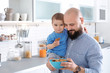 © New Africa - Dad having breakfast with little son in kitchen