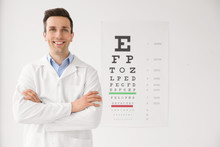 Young Ophthalmologist Near Eye Chart Indoors