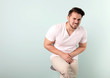 © New Africa - Young man with urological problems suffering from pain on color background