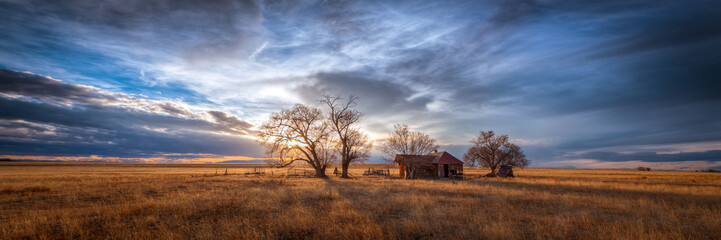 old farmhouse at sunset in the countryside