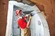 © Kadmy - Worker sawing doorway with sabre saw. Home renovation