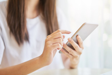 Wall Mural - Woman using smartphone for the application on table in room. Concepts for digital technology in everyday Life.