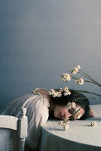 Woman Sleeping On Table With Flowers