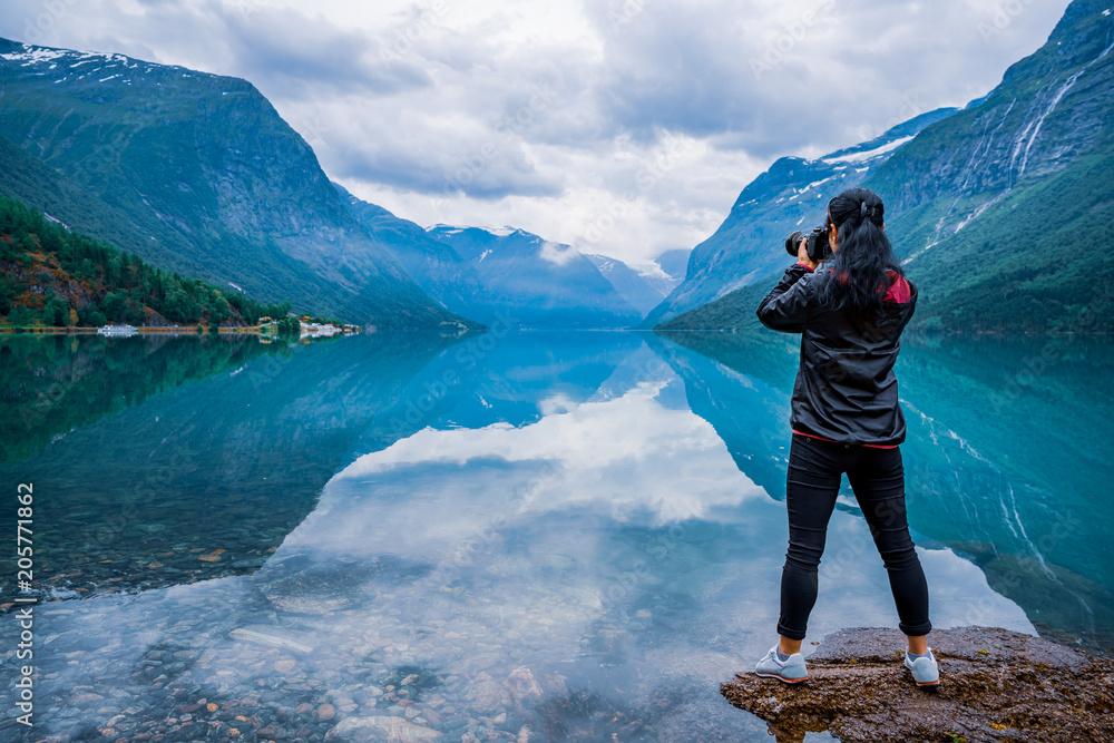 Nature photographer tourist with camera shoots lovatnet lake Beautiful Nature Norway. - obrazy, fototapety, plakaty 