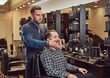 © Fxquadro - Professional barber working with client in a hairdressing salon.