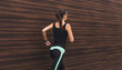 © Prostock-studio - Young woman running in city copy space