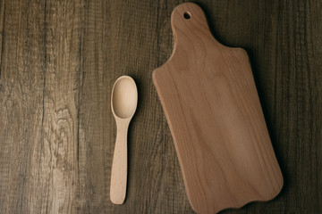 Wall Mural - a wooden spoon and a wooden cutting board lie on a wooden table.