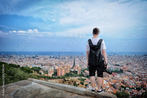 Zdjęcie XXL Młody człowiek turysta stoi na krawędzi dachu i patrząc na miasto. Barcelona. Hiszpania