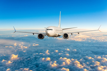 front view of aircraft in flight. the passenger plane flies high above the clouds and blue sky. busi