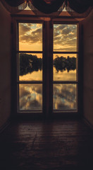 Wall Mural - Clouds reflected in the lake at sunset. View through the window