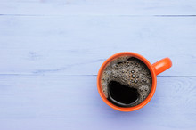 Orange Coffee Cup On A Blue Wooden Background. View From Above.