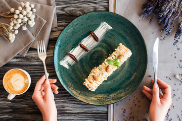 Wall Mural - cropped shot of person holding fork with knife and eating delicious dessert with almonds