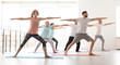 © New Africa - Group of people in sportswear practicing yoga indoors