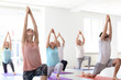 © New Africa - Group of people in sportswear practicing yoga indoors