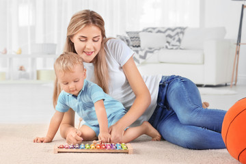 Canvas Print - Baby and mother playing with toy xylophone at home