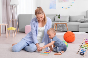 Canvas Print - Baby and mother playing with toy xylophone at home