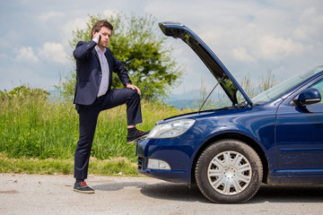 Wall Mural - A broken car on the road, a man talks to a cell phone and calls for help on the road