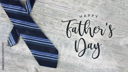 Stampa su Tela  Happy Father's Day Text with Striped Tie Over Light Wood Background