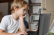 © Denys Kurbatov - Portrait of young blond boy working on laptop computer at home