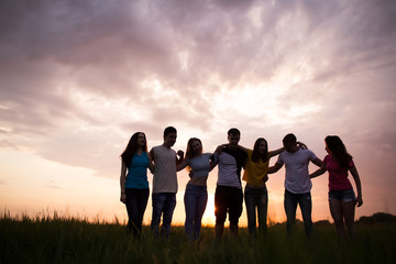 Wall Mural - Silhouettes of people againstl sunset sky