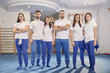 large team, group of physical therapists  workers posing, work room indoors.