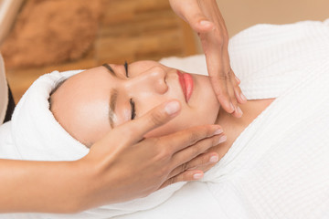 Face massage. Spa skin and body care. Close-up of young woman getting spa massage treatment at beauty spa salon. Facial beauty treatment.