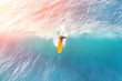Surfer on a yellow surfboard in the ocean on a sunny day