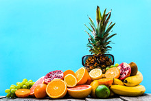 Tropical Fruit Mix On Blue Background, Pile Of Colorful Fruits On Table And Sunglasses, Summer Background