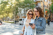 © Drobot Dean - Two amazing women friends using mobile phone.