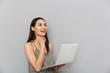 © Drobot Dean - Portrait of a happy asian woman using laptop computer
