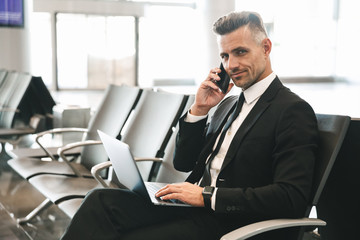 Wall Mural - Smiling mature businessman talking on mobile phone