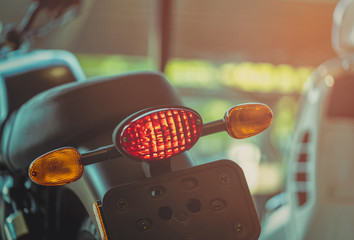 Motorcycle break and turn signal light on blurred background. New big bike park in showroom. Motorbike dealership concept. Parts of motorcycle. Motorcycle license test concept.