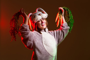 Happy bunny girl with carrots on dark background