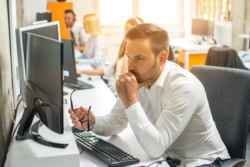 Wall Mural - Worried young business man working on computer at office