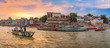 Varanasi India city architecture panoramic view with tourists boat at sunset.