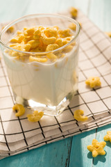 Wall Mural - cup of milk with cereal rings in a sunny morning as healthy breakfast