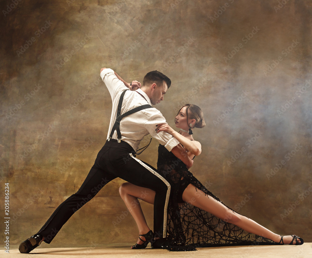 Flexible young modern dance couple posing in studio. - obrazy, fototapety, plakaty 