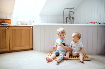 Wall Mural - Two toddler children brushing teeth in the bathroom at home.