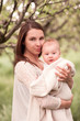 © morrowlight - Beautiful woman holding baby boy outdoors. Looking at camera. Happy motherhood.