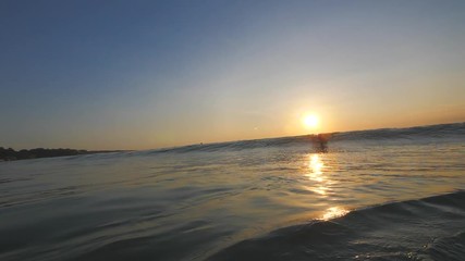 Wall Mural - slow motion shot of sunset surfing wave in indonesia at bali island
