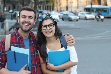 Two mixed race students smiling outdoors 