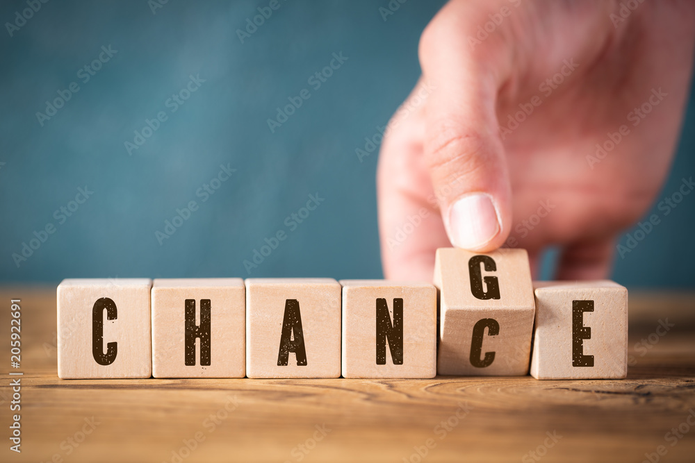 Hand flips one of six cubes with letters, turning the word "change" to "chance" - obrazy, fototapety, plakaty 