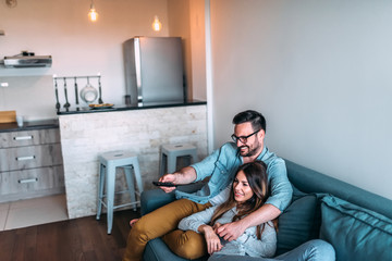 Wall Mural - Young couple watching tv.