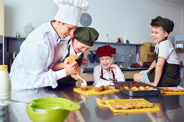 Wall Mural - Children learn to cook in the classroom in the kitchen.