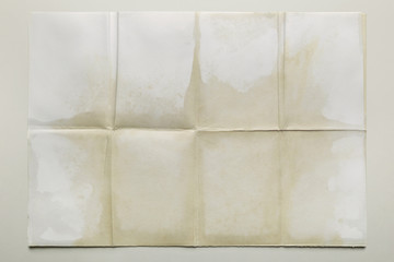 Empty sheet folded in eight, old paper isolated on gray background