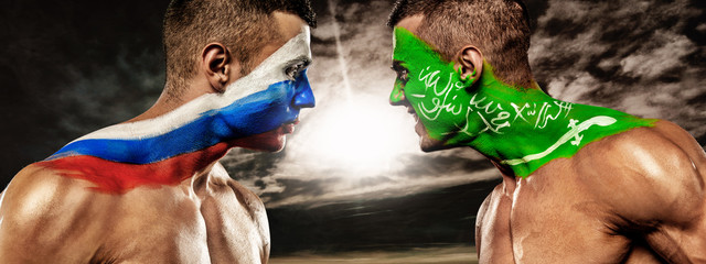 Russia vs Saudi Arabia. Two soccer or football fans with flags face to face on stadium.