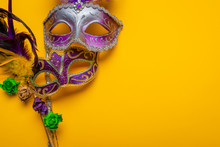 Two Mardi Gras Mask With Colorful Beads On A Yellow Background