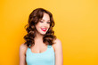 © deagreez - Portrait with copyspace empty place of foxy funny girl with modern hairdo winking with one eye having beaming smile red pomade lipstick isolated on yellow background